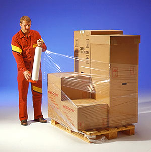 Мужчина упаковывает в стрейч-пленку груз